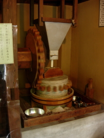 水車小屋の中で石臼がそば粉を挽く