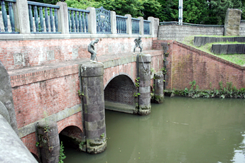 橋の上の像は川の氾濫の際に必死に堰板を差している姿