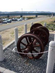 八高線列車衝突事故の碑。昭和20年に起きた日本鉄道史上有数の重大事故で、鉄橋下から発見された事故車両の車輪を展示。設置場からは八高線鉄橋が見える